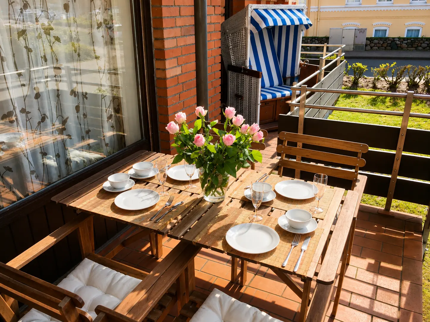 Sonniger Balkon der Ferienwohnung in Westerland mit Sitzbereich und blau-weißem Strandkorb